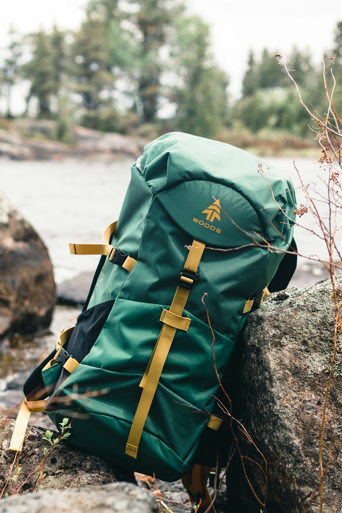 Green hiking backpack on rocks